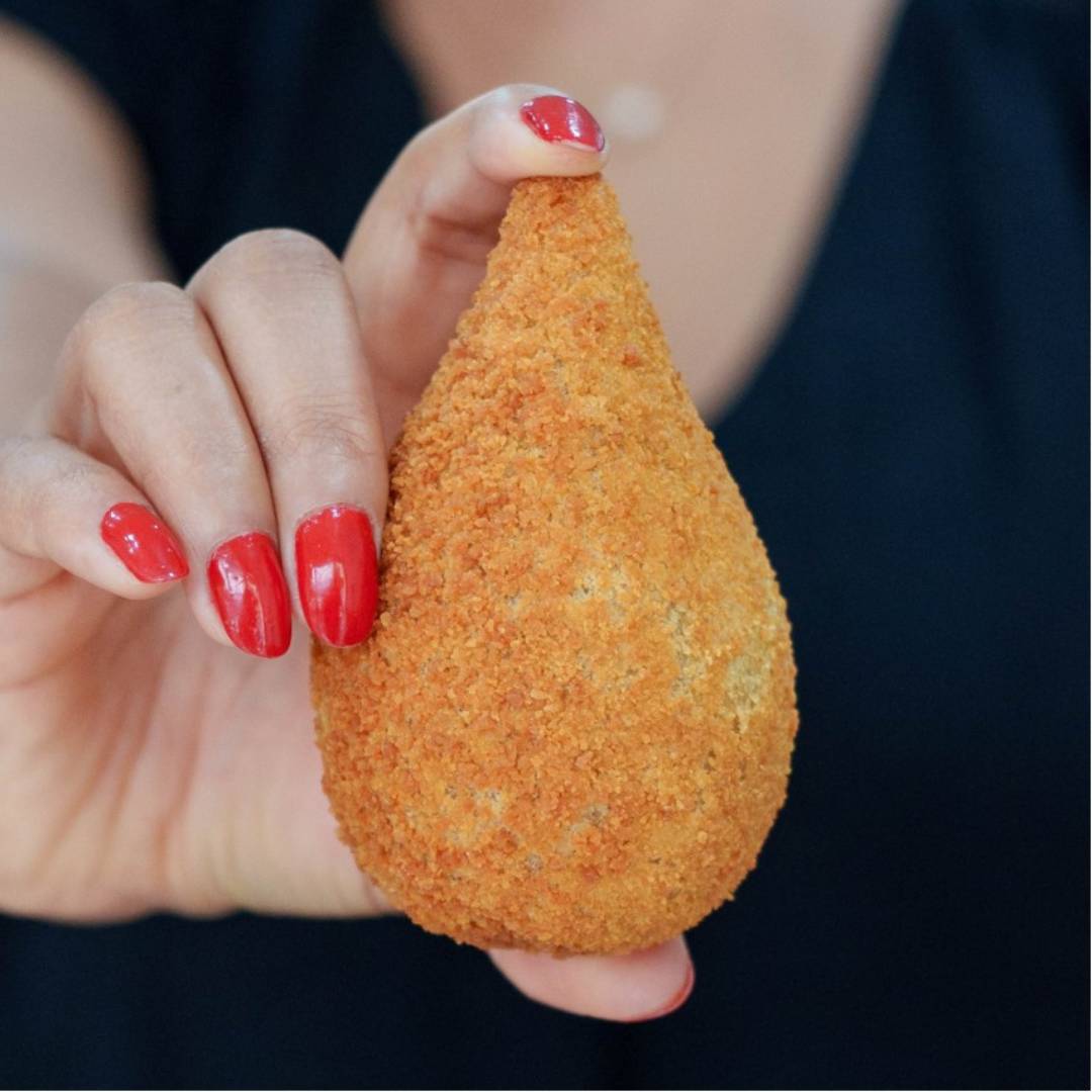 Photo d'une coxinha maison tenue à la main, spécialité du restaurant brésilien à Lyon